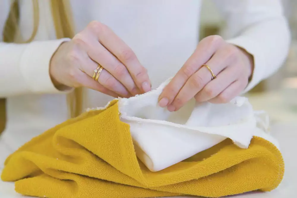 Eine Modedesignerin oder Schneiderin arbeitet in einem Workshop mit farbigen Stoffen an einem Entwurf.