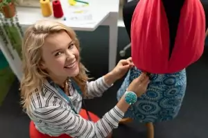 Modedesignerin kleidet eine Schaufensterpuppe in ihrem Designstudio ein.