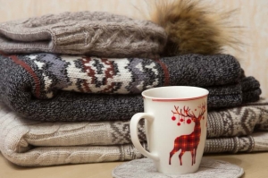 Stapel Winterkleidung und eine Tasse